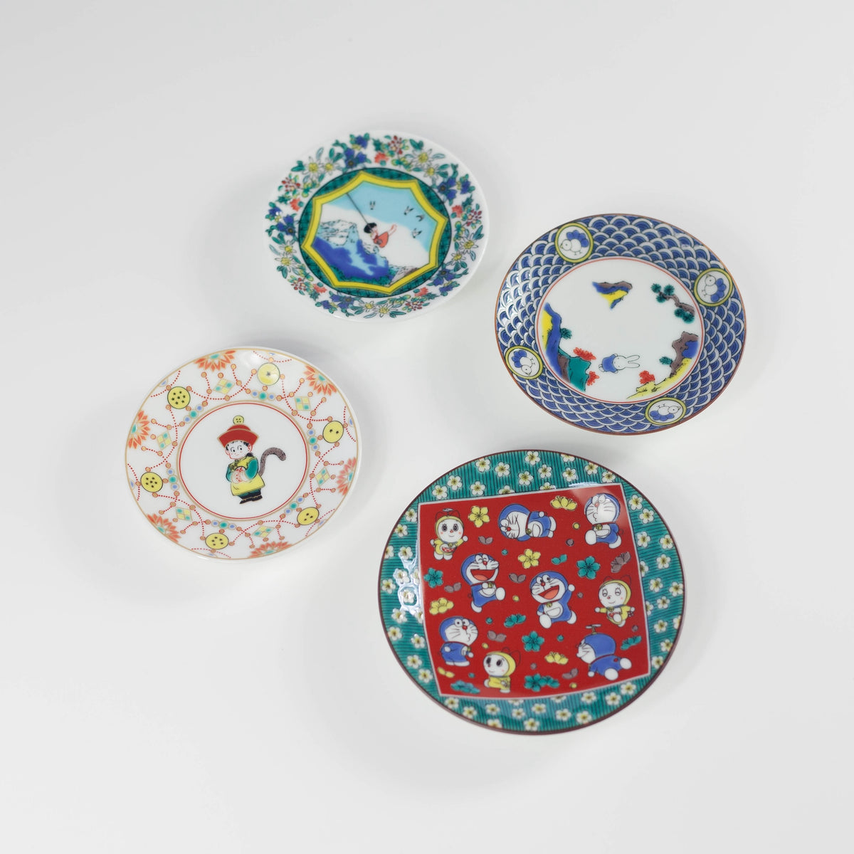 Set of four decorative plates with colorful designs on a white background
