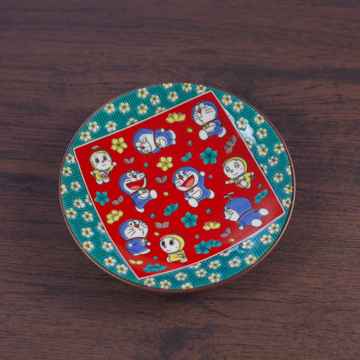 Decorative plate with Doraemon design on a wooden surface