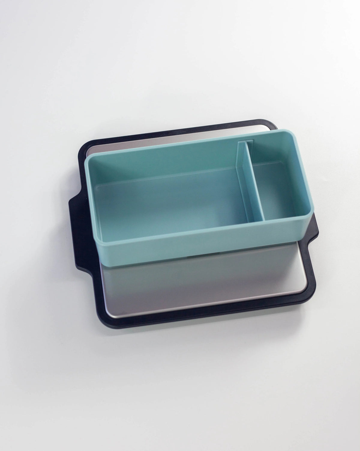 Gel-Cool Rapid Cooling Plate in black with a two-compartment mint green tray placed on top, showing how the plate can be used as a base to rapidly cool bento contents, on white background