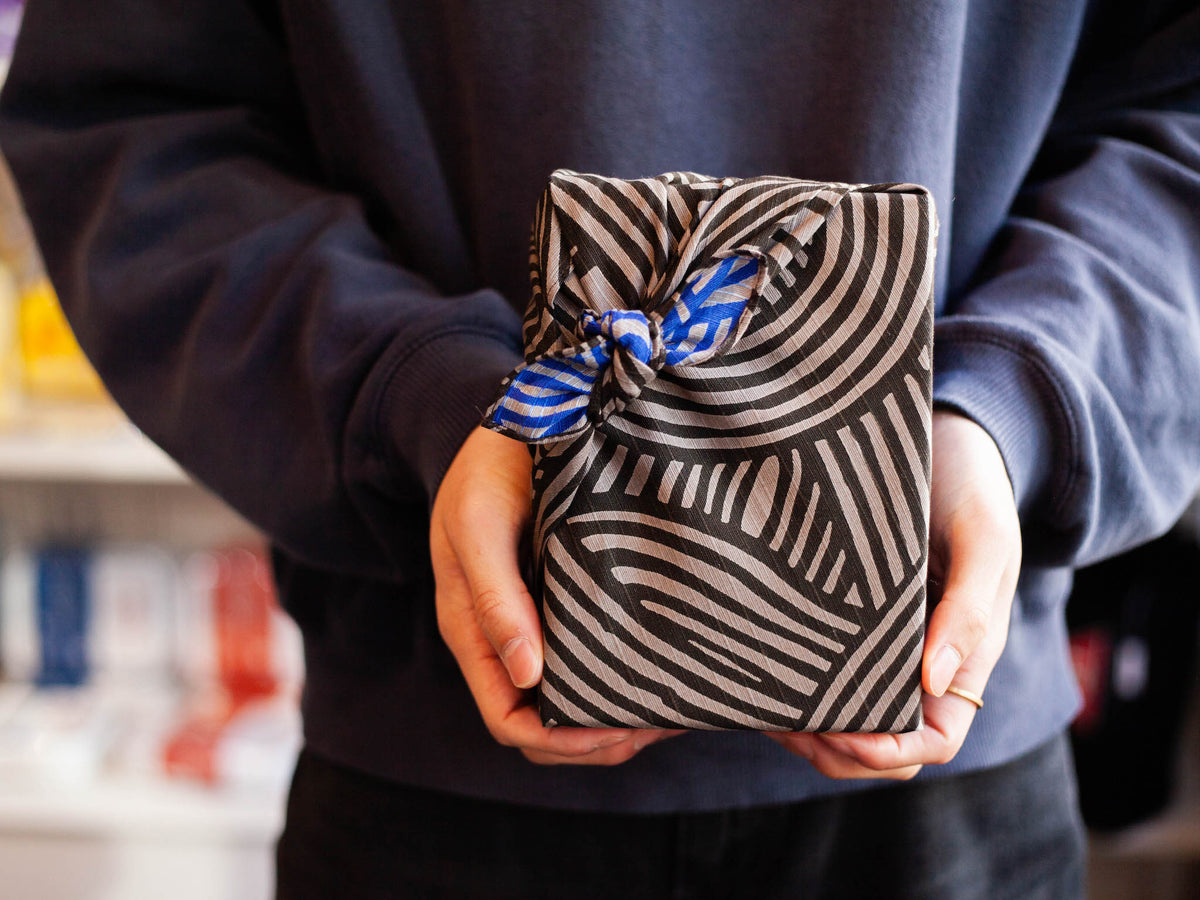 Isa Monyo Reversible Furoshiki 48cm Knot Gray Blue – double-sided Japanese wrapping cloth showing gray and black knot pattern on one side and blue knot pattern on the other, 100% cotton, made in Japan
