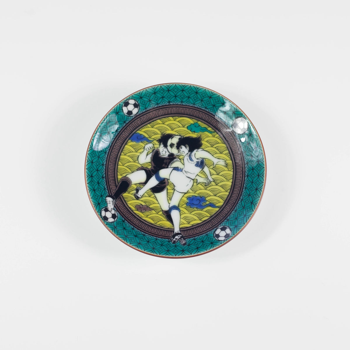 Decorative plate with artistic design of two figures playing soccer on a green background