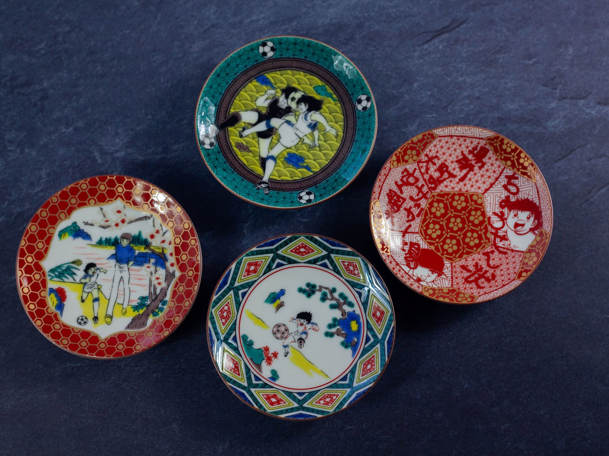 Four colorful decorative plates with various soccer cartoon designs on a dark blue background