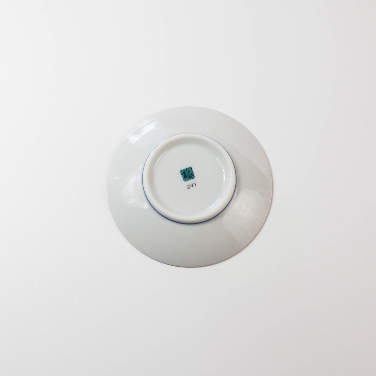 White ceramic plate with a visible brand logo on a white background