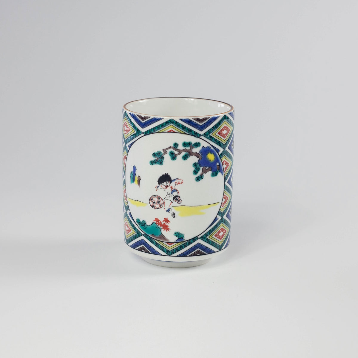 Decorative ceramic cup with colorful soccer-themed design on a white background