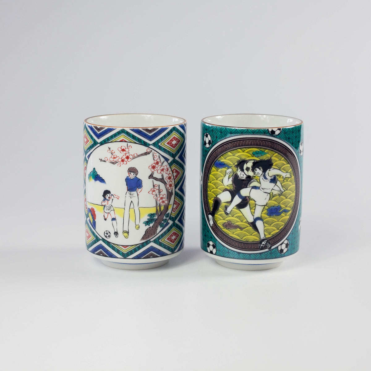 Two ceramic cups with artistic Captain Tsubasa designs on a white background