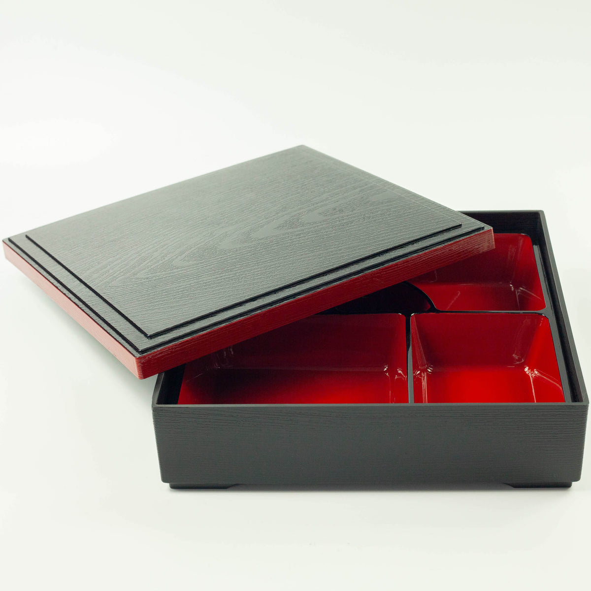 Japanese lacquerware-style bento box with black wood-grain textured lid and dark red base, elegant square lunch box, made in Japan