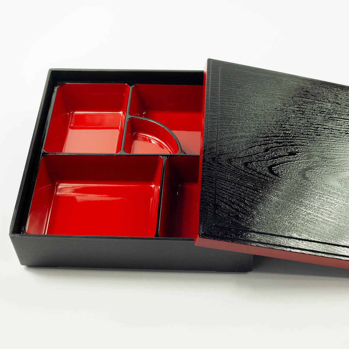 Japanese lacquerware-style bento box with black wood-grain textured lid and dark red base, elegant square lunch box, made in Japan