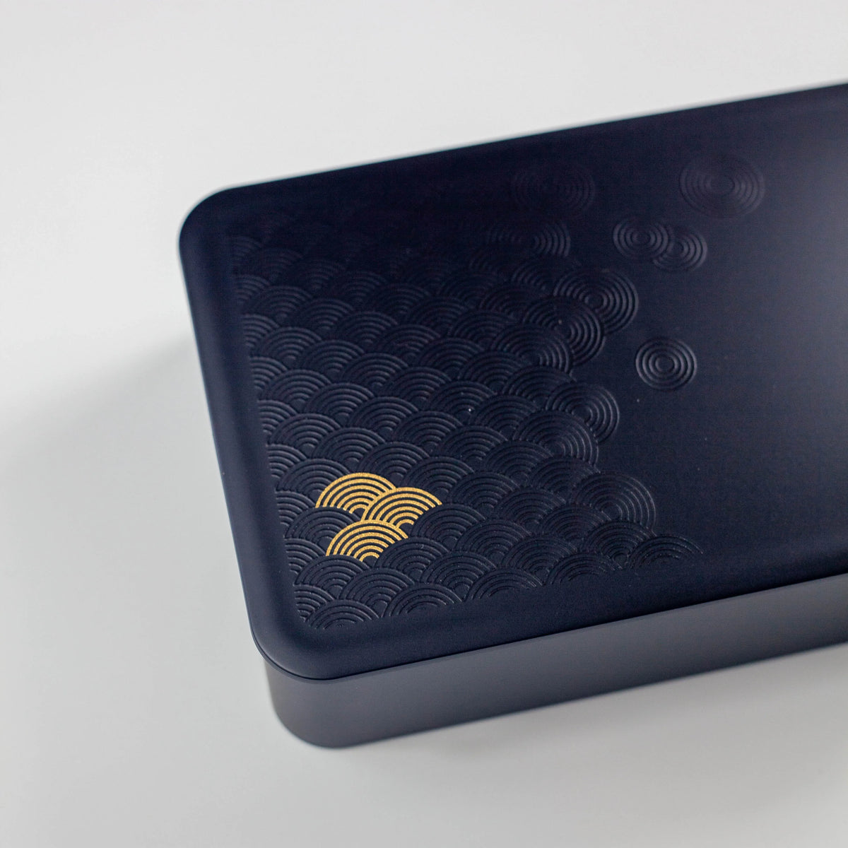 Wamon Bento Box 800mL – matte black with gold seigaiha wave pattern and black elastic band, front view