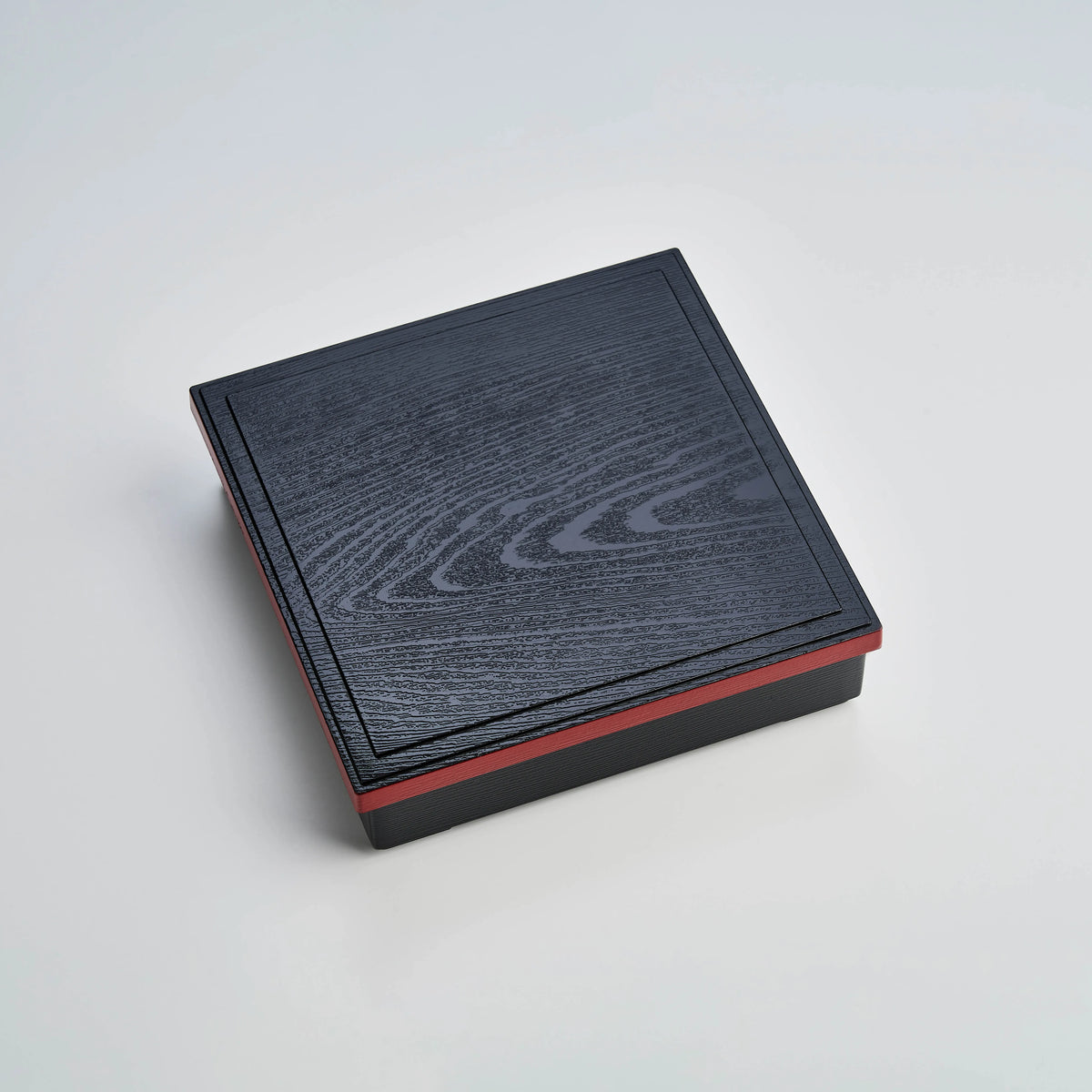 Japanese lacquerware-style bento box with black wood-grain textured lid and dark red base, elegant square lunch box, made in Japan