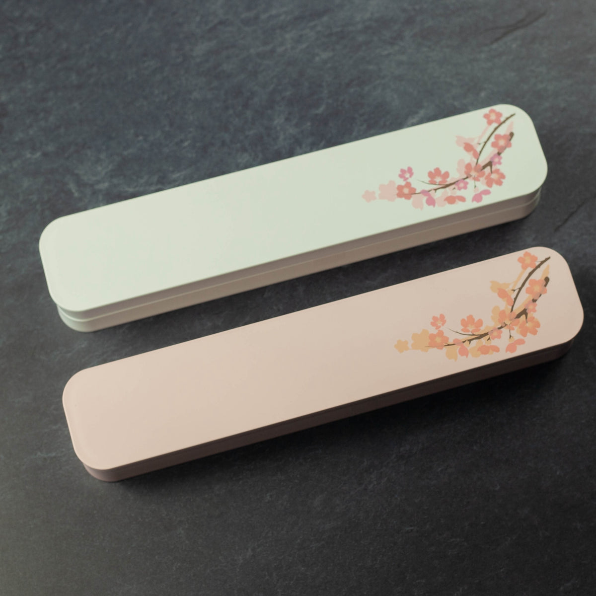 Sakura Cutlery Set white case closed, angled view showing pink cherry blossom branch design on white background