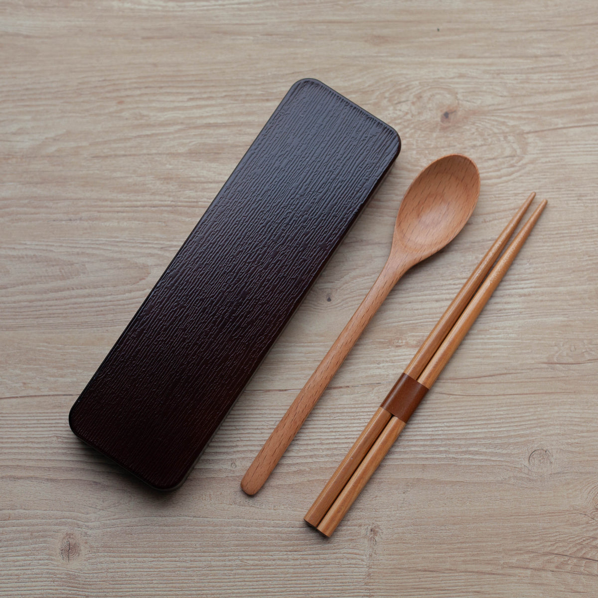Dark brown wooden cutlery set with chopsticks, spoon and sliding case