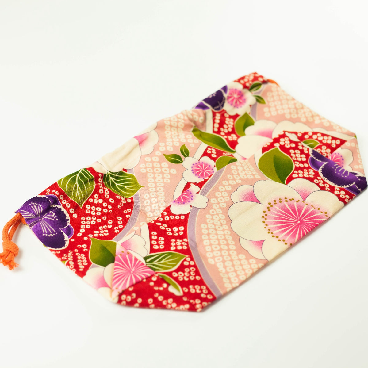 Kimono Sakura Pink bento drawstring bag closed with orange cord tie, pink and red Japanese floral fabric with white sakura, purple and pink flowers, white background