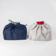 Water Repellent Drawstring Bag in navy blue with grey cord and light grey with red cord, front view on white background
