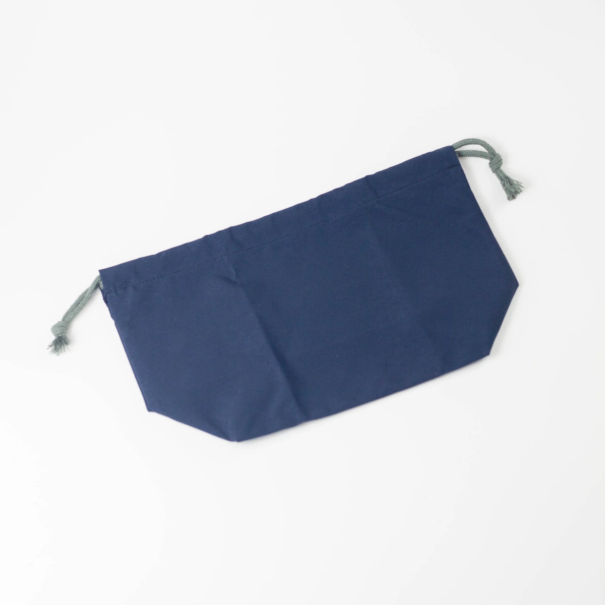 Close-up of water repellent fabric surface showing water droplets beading on light grey drawstring bag