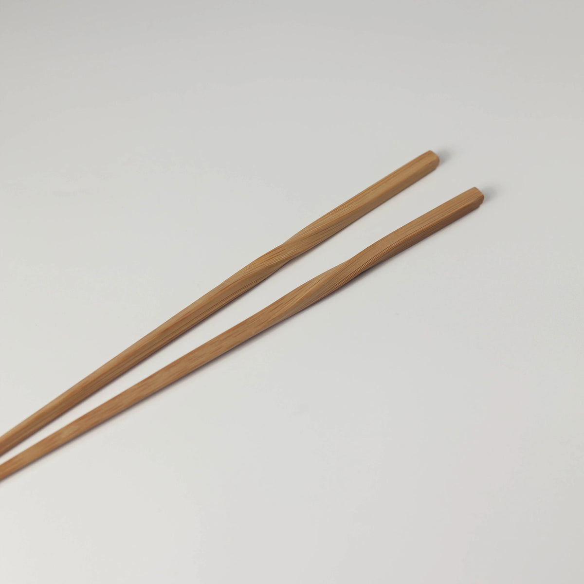 Long bamboo chopsticks showing their twisted handles and natural bamboo grain
