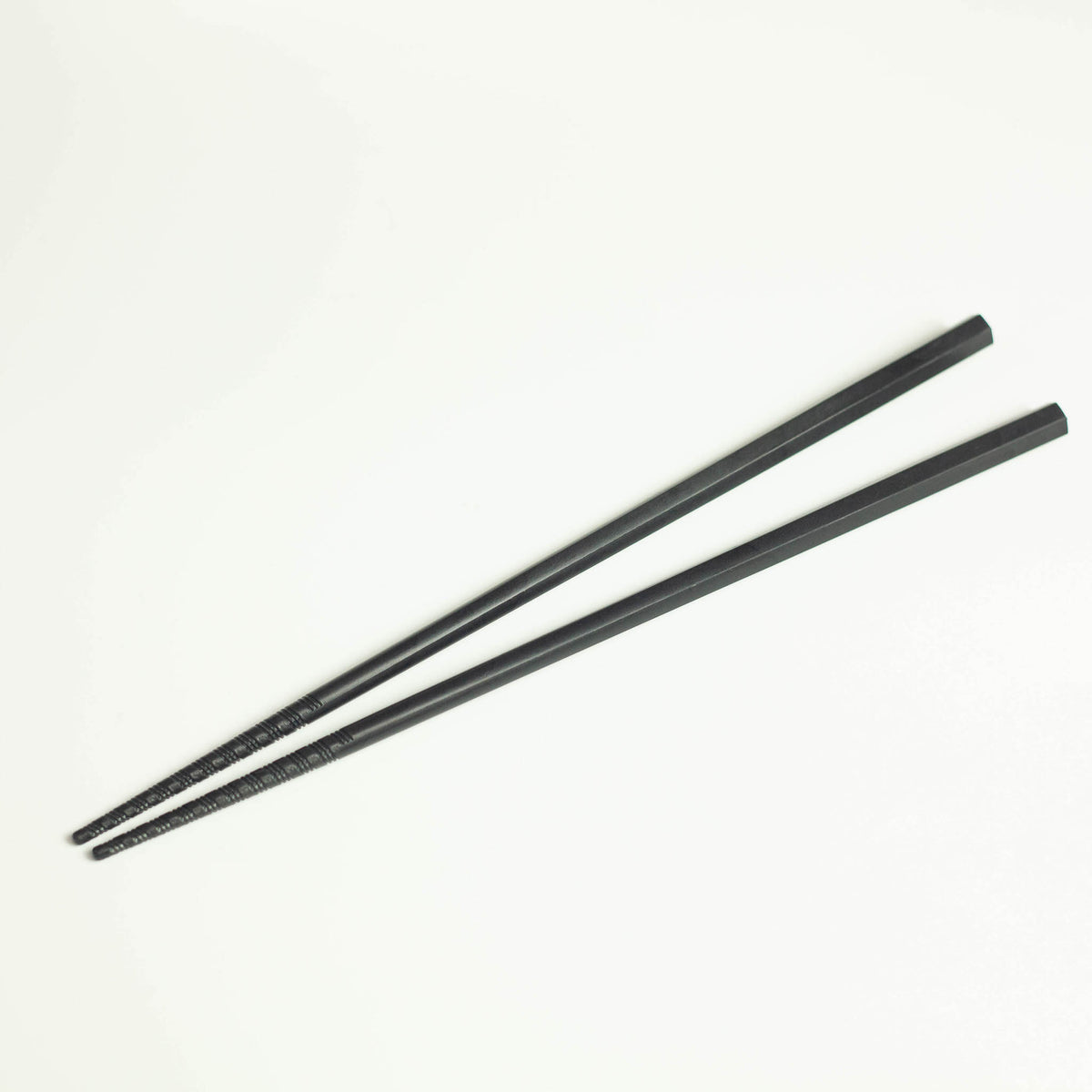Tornado Chopsticks – pair of matte black resin chopsticks with tornado-grip tips, white background
