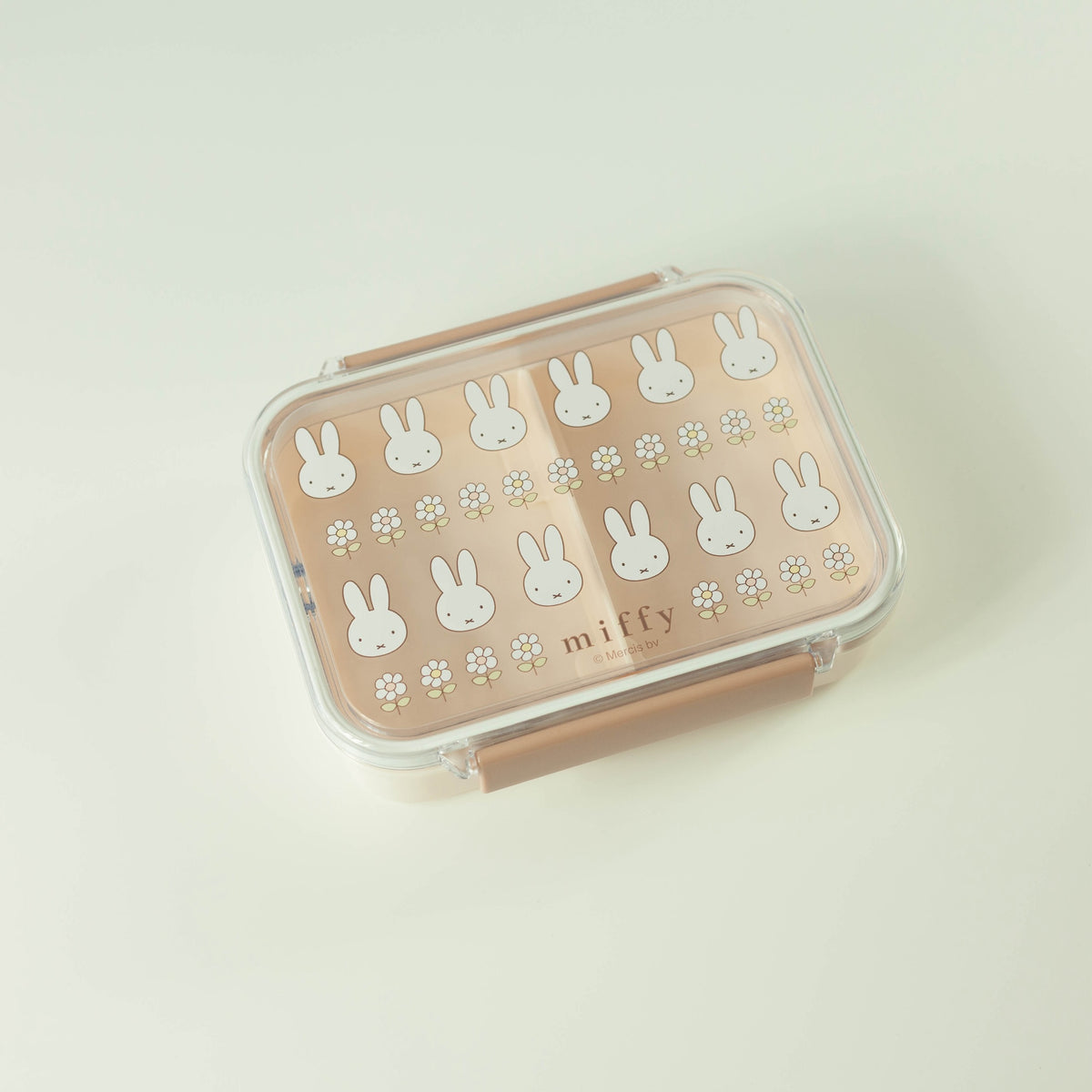 Pink lunch box with white bunny patterns on a light beige background
