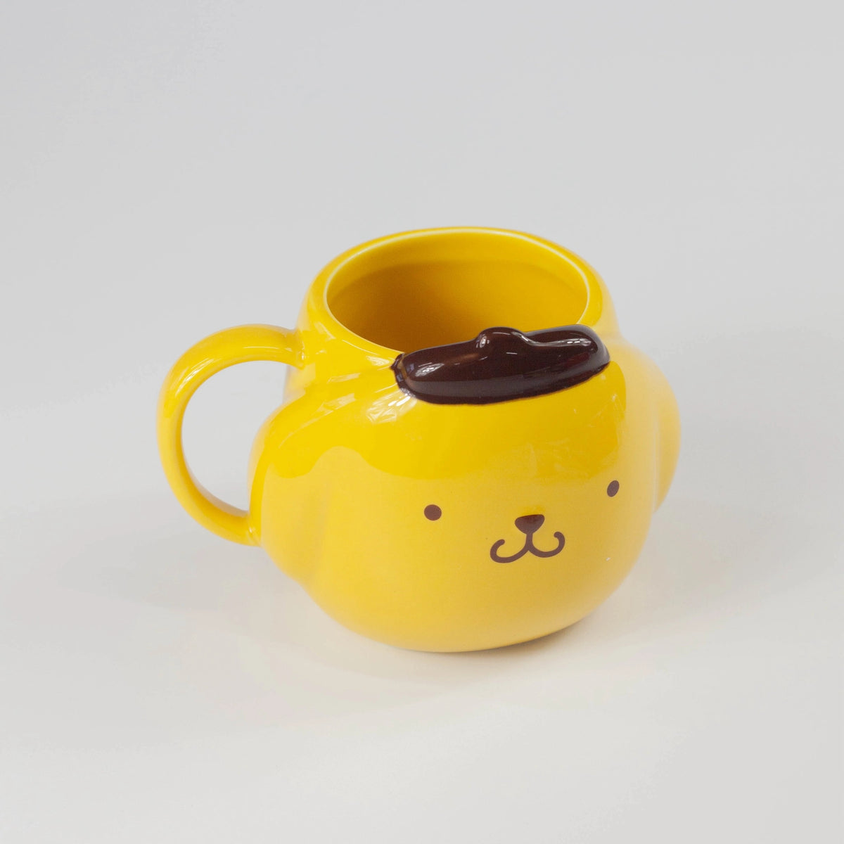 Yellow mug with a dog face design on a grey background