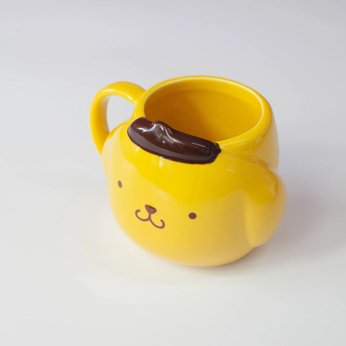 Yellow mug with a handle and a brown tuff of hair on a white background