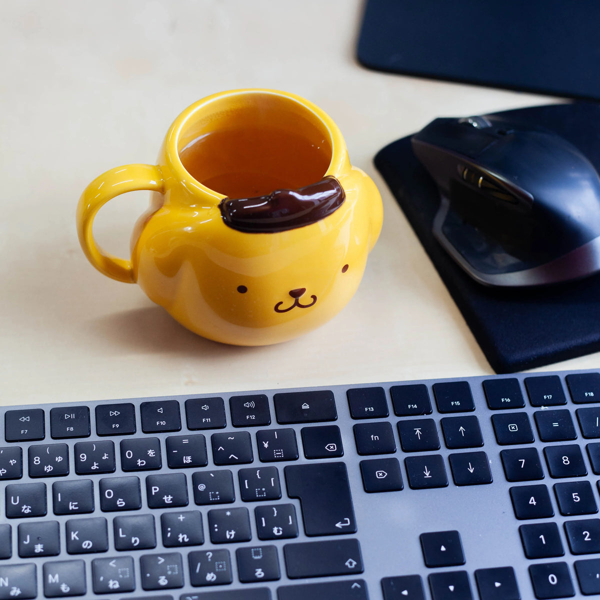 Yellow mug with a labrador design on a desk with a keyboard and mouse.
