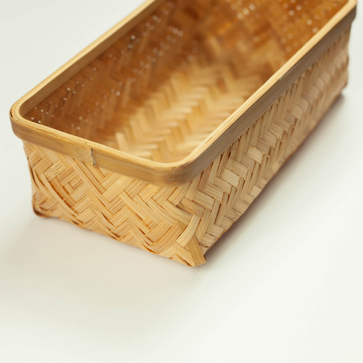 lose-up of Woven Bamboo Bento Box interior showing deep rectangular compartment and herringbone bamboo lining, angled view