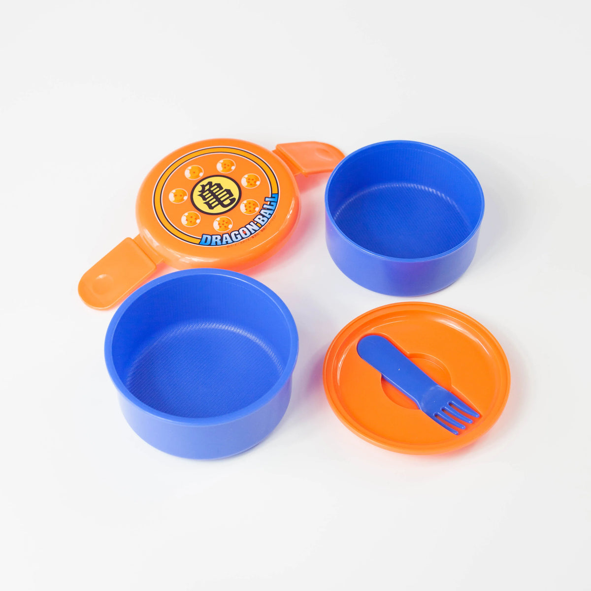 Dragon Ball round bento box disassembled to show two blue containers, orange lids, and a small blue fork