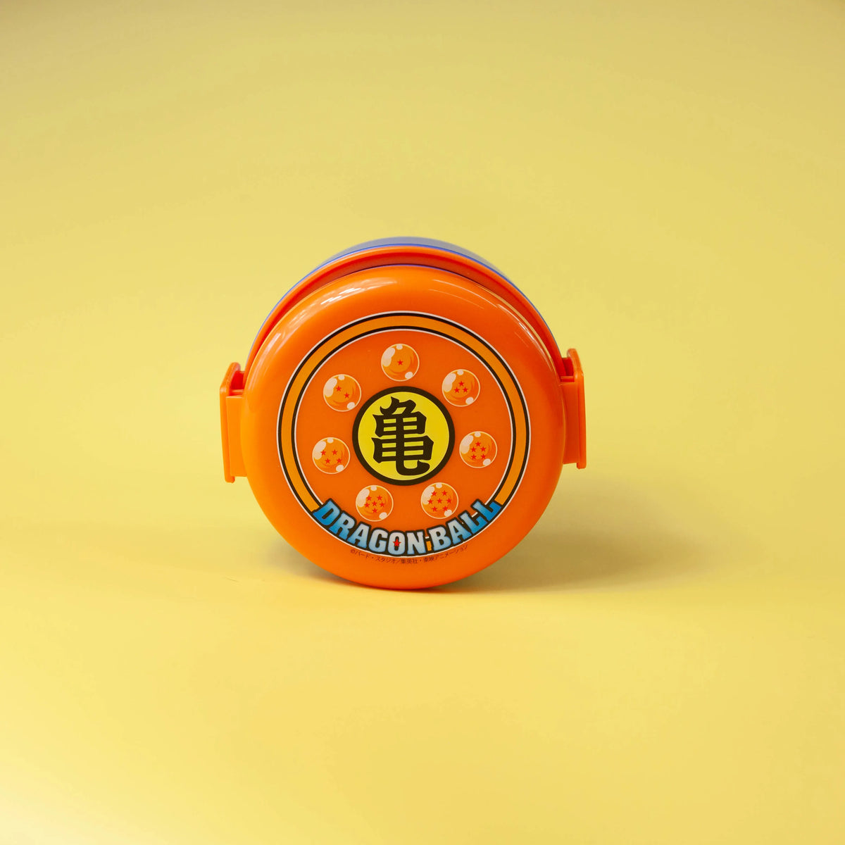 Dragon Ball two-tier round bento box with blue containers, an orange lid, and closed side clips