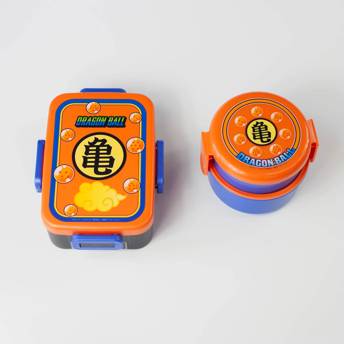 Dragon Ball rectangular and round bento boxes side by side with orange lids and matching Kame emblem designs