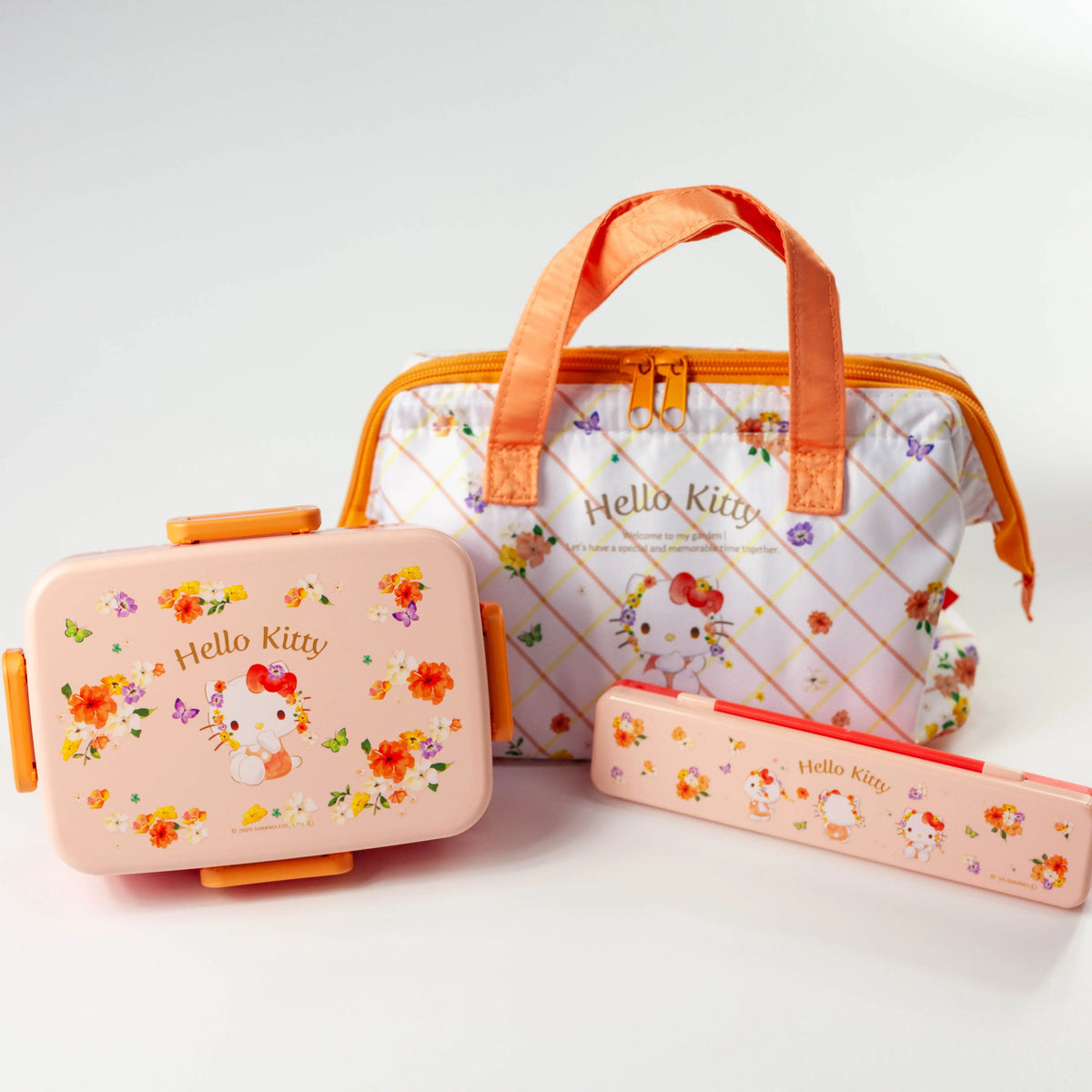 Hello Kitty Vivid Pastels bento set with the lunch box displayed upright beside the floral lunch bag and matching cutlery case