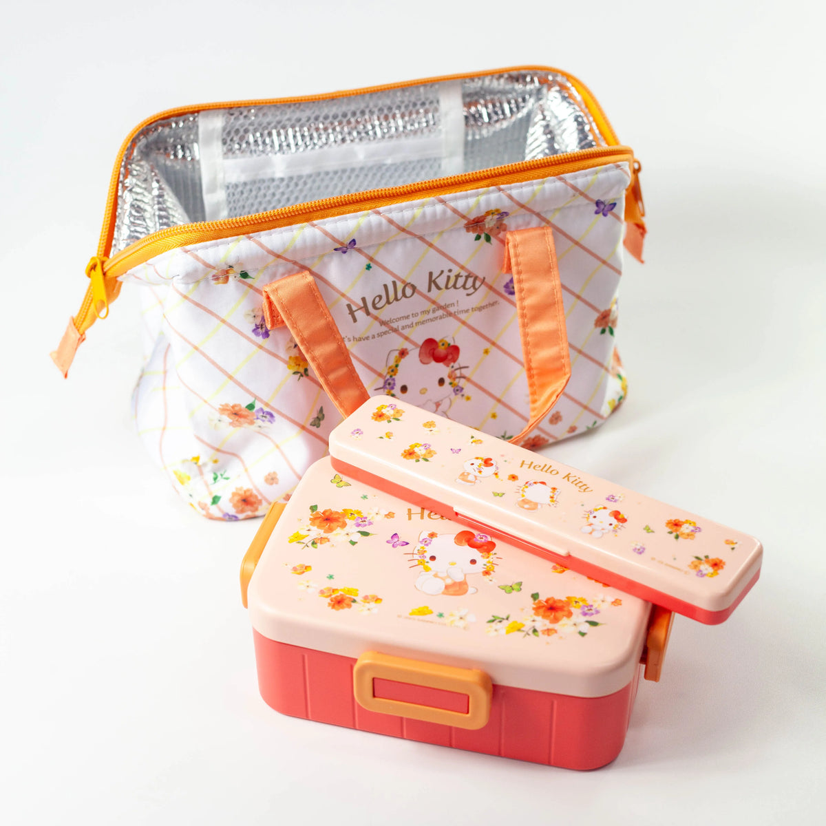  Hello Kitty bento box and matching cutlery case in front of an open lunch bag showing its silver insulated lining
