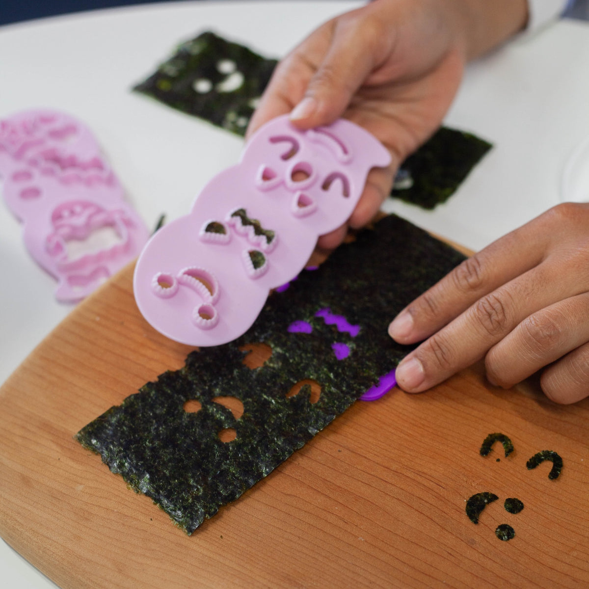 Arnest Ghost Onigiri Set retail packaging – three pink ghost-face nori punches and a white ghost-shaped rice mold with handle on a dark Halloween-themed Japanese card showing example ghost onigiri, on white background
