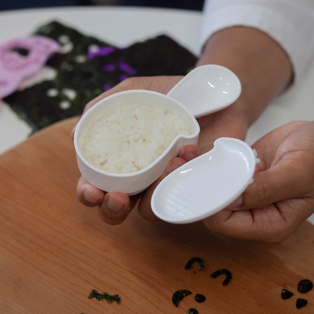 Arnest Ghost Onigiri Set retail packaging – three pink ghost-face nori punches and a white ghost-shaped rice mold with handle on a dark Halloween-themed Japanese card showing example ghost onigiri, on white background
