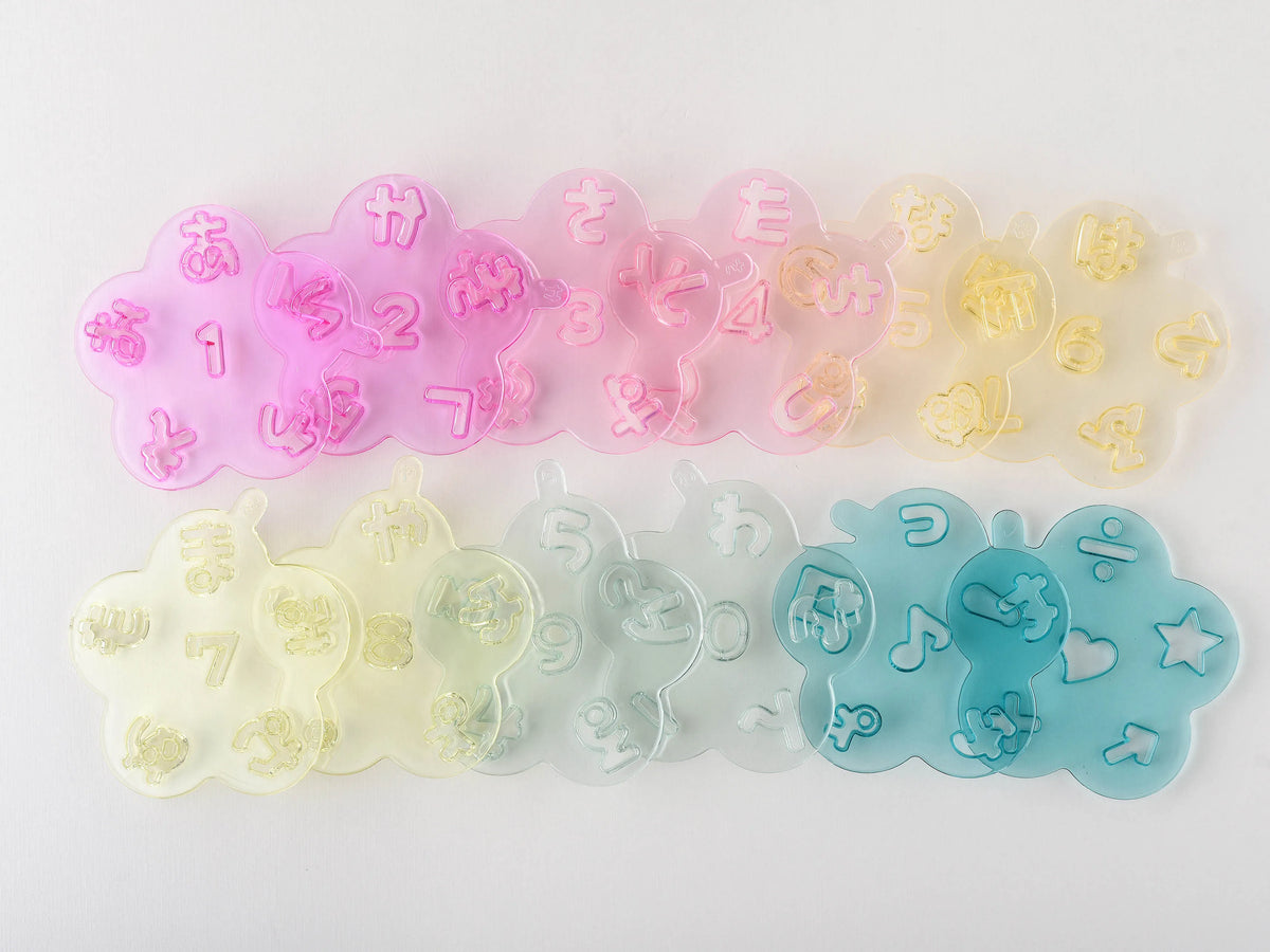 Hiragana Cutter Set – all 12 pastel-colored trays laid out showing complete hiragana, numbers, and symbol cutters, white background