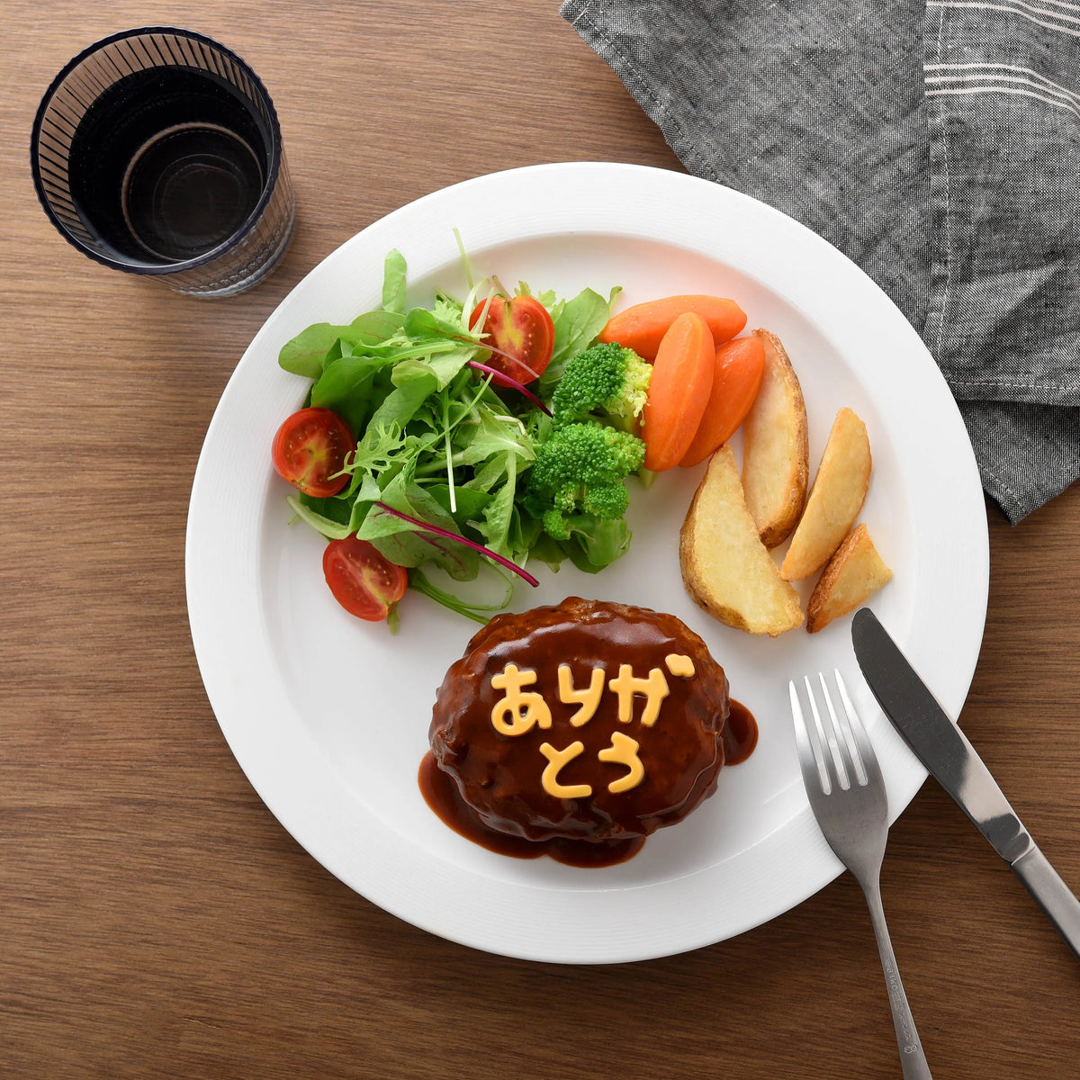 Hiragana Cutter Set in use – "arigatou" (thank you) spelled out in cheese on a hamburger steak plate with salad and potato wedges
