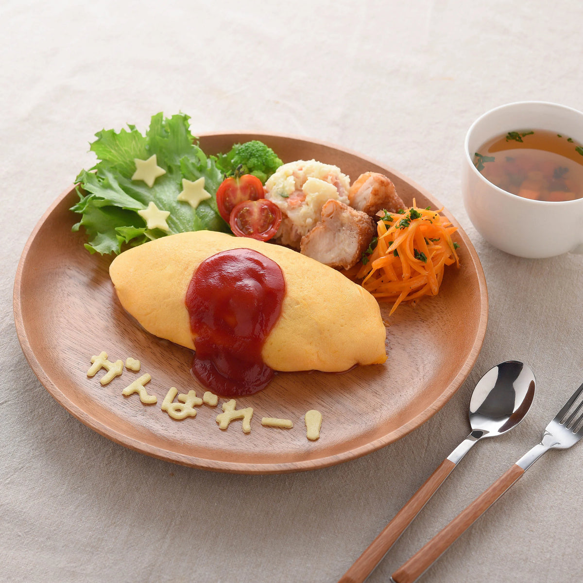Hiragana Cutter Set in use – "arigatou" (thank you) spelled out in cheese on a hamburger steak plate with salad and potato wedges