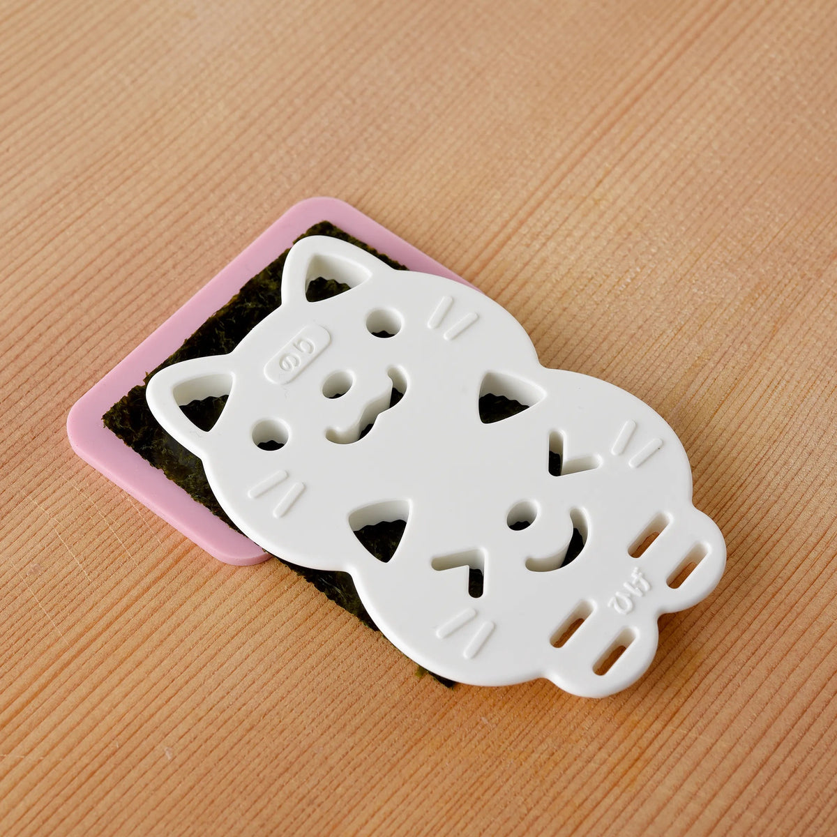 Neko Kao Onigiri Set contents – pink cat rice mold, nori sheet cutter, and face detail stamp, white background angled view