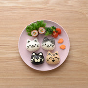 Neko Kao Onigiri Set – pink cat-shaped rice mold, nori cutter, and face stamp laid out on the table.