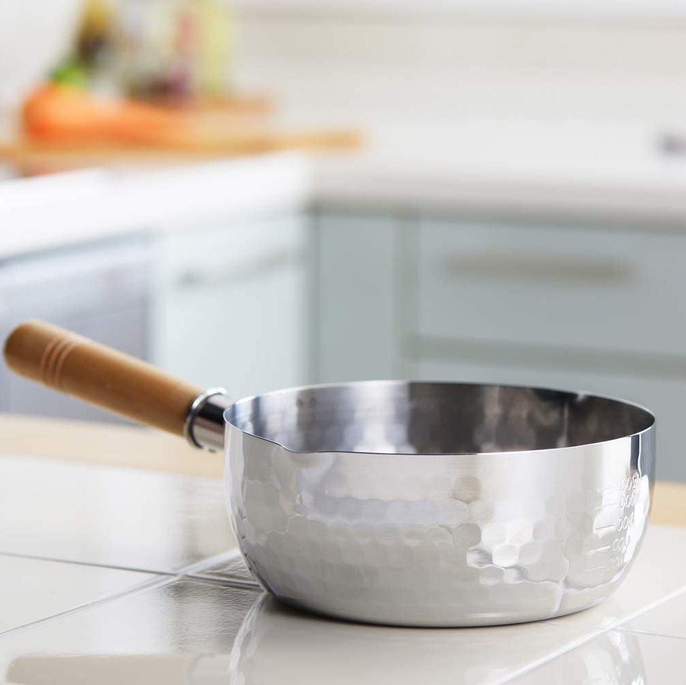 YukiHira Nabe Pot 18cm – polished stainless steel hammered saucepan with wood handle on white kitchen countertop, lifestyle shot