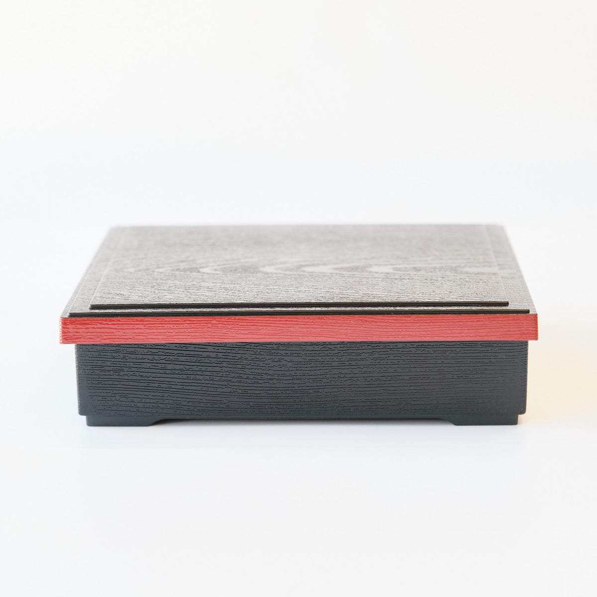 Japanese lacquerware-style bento box with black wood-grain textured lid and dark red base, elegant square lunch box, made in Japan