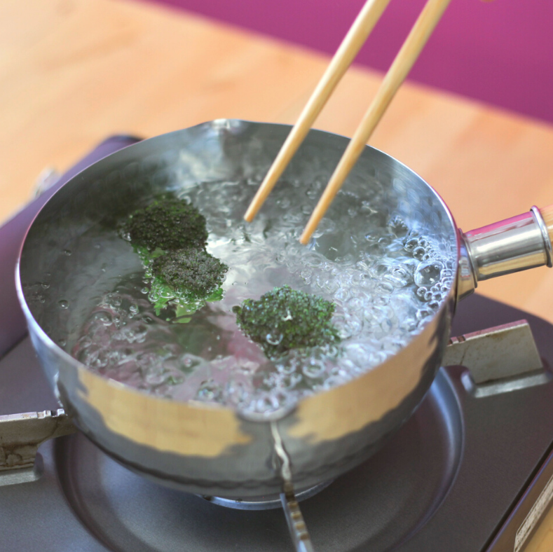 YukiHira Nabe Pot 18cm – polished stainless steel hammered saucepan with wood handle on white kitchen countertop, lifestyle shot